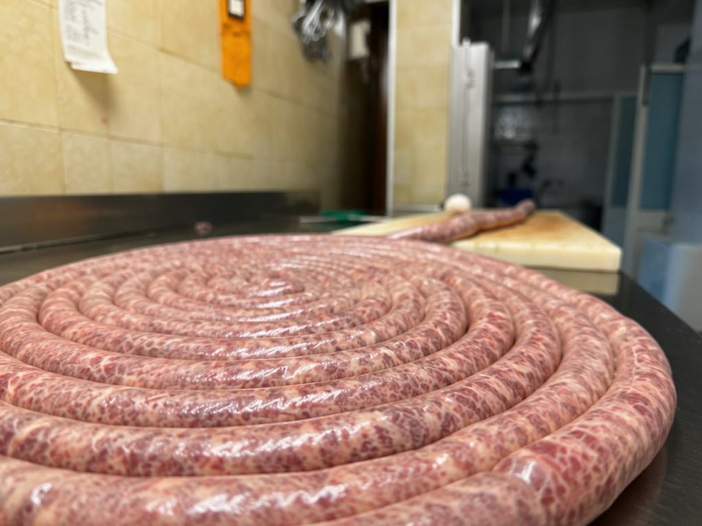 La salsiccia a rotolo appena fatta, pronta per la brace